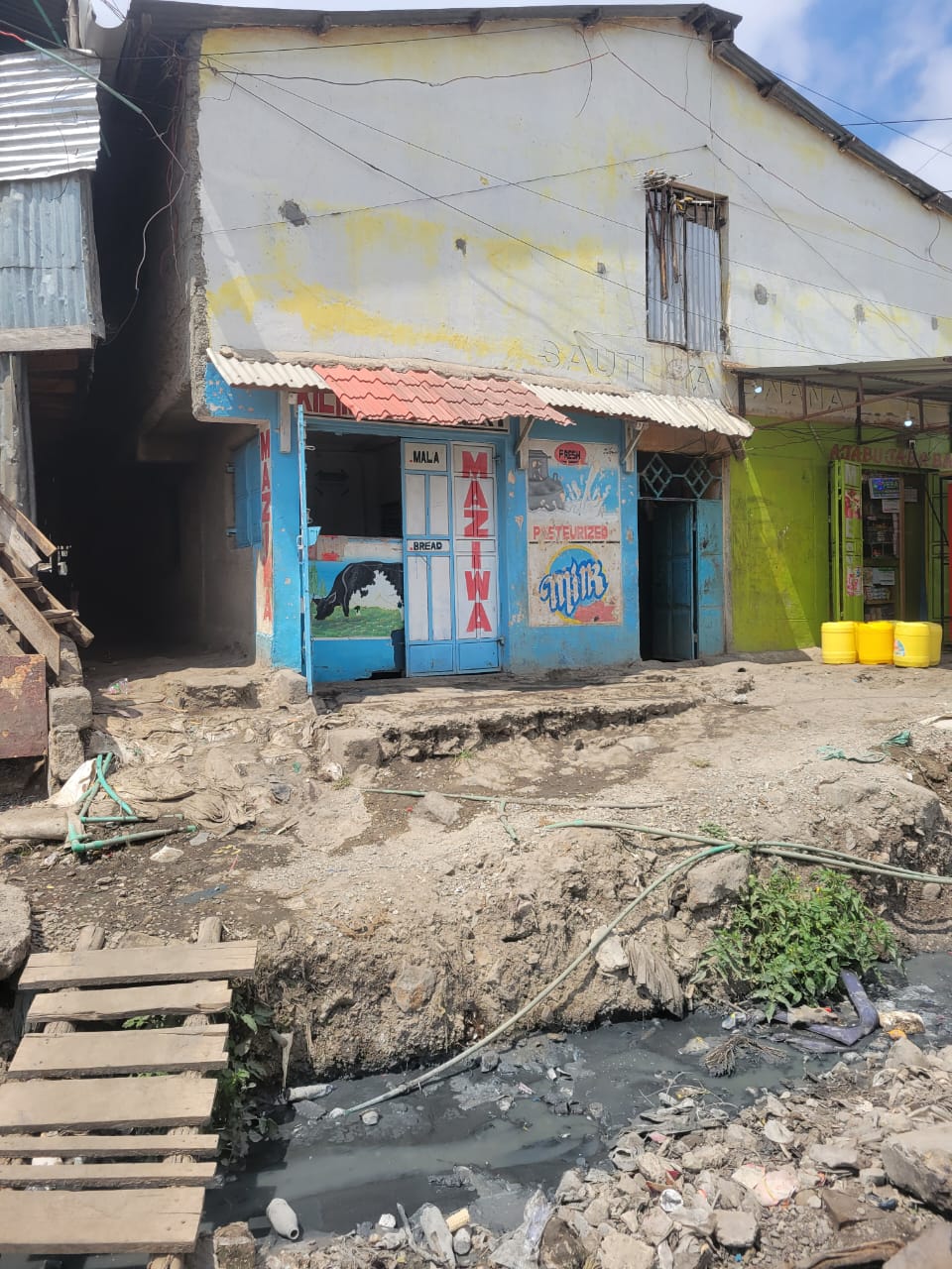 An open sewer passes at the doorstep of milk vending shop in Mukuru Fuata Nyayo || PHOTO BY Elvis Omondi. An open sewer passes at the doorstep of milk vending shop in Mukuru Fuata Nyayo || PHOTO BY Elvis Omondi.